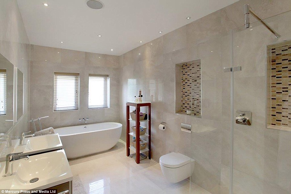 The beautiful bathroom includes a standalone bath, two ceramic sinks, a large shower area and two mirrors 